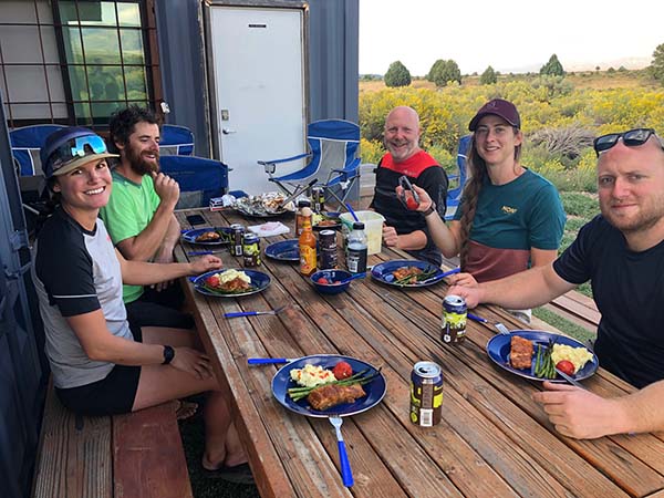 group of riders eating dinner at the huts